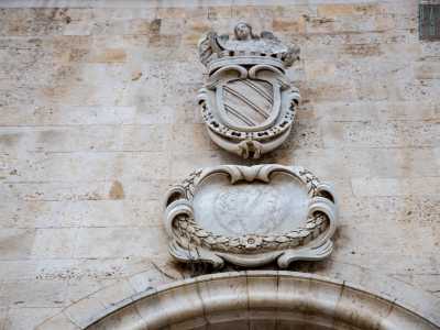 ul grande portone � affisso lo stemma dei Filomarino sormontato da un angelo che regge un cartiglio con su scritto �sat unus�. Immediatamente sotto, un altro elemento decorativo sembra rappresentare una clessidra con i simboli dello zodiaco